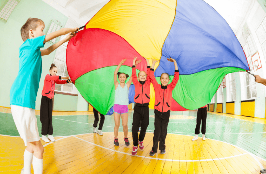 children at holiday club playing with a parachute silk