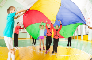 children at holiday club playing with a parachute silk