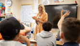 Teacher stands in front of a class of school children